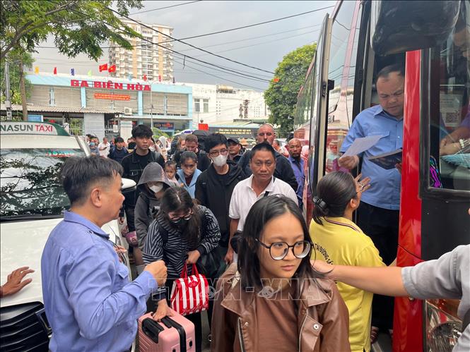 Những hành khách đầu tiên trên tuyến tàu từ Bắc vào Nam phải trung chuyển bằng đường bộ tại ga Biên Hòa chiều 6/3. Ảnh: Sỹ Tuyên - TTXVN
