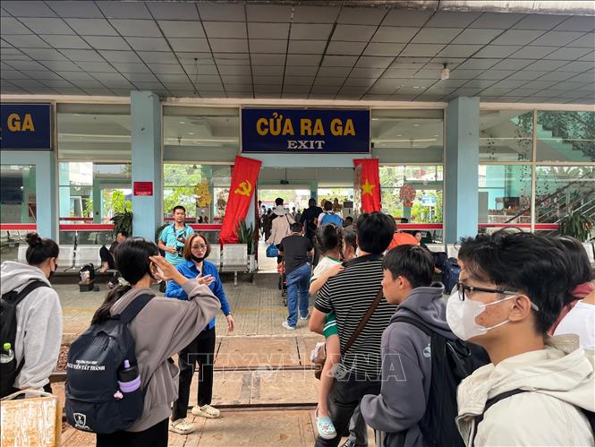 Hành khách trên tuyến tàu từ Bắc vào Nam khi dừng tại ga Biên Hòa để trung chuyển bằng đường bộ đến Thành phố Hồ Chí Minh được lực lượng thanh niên hướng dẫn chuẩn bị lên xe bus vào chiều 6/3. Ảnh: Sỹ Tuyên - TTXVN