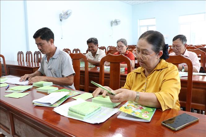 Bà Nguyễn Thị Phương Thắm (hàng trên, bìa phải), Bí thư Chi bộ khóm 1, phường Trà Vinh và các đảng viên đang chuẩn bị phiếu cử tri để phát cho người dân. Ảnh: Thanh Hòa- TTXVN