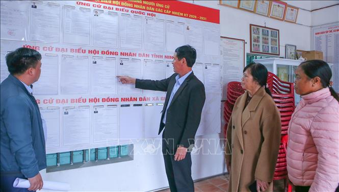 Các thành viên Tổ bầu cử số 7, xã Giao Ninh kiểm tra, rà soát lại các thông tin các ứng cử viên được niêm yết tại điểm bỏ phiếu. Ảnh: Công Luật - TTXVN