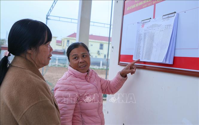 Các thành viên Tổ bầu cử số 7, xã Giao Ninh trao đổi, rà soát lại thông tin của các cử tri trên địa bàn. Ảnh: Công Luật - TTXVN