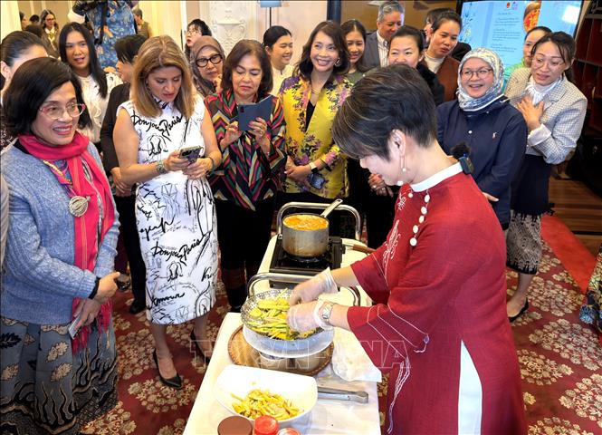 Khách mời sử dụng điện thoại lưu lại cách chế biến món chay Việt Nam dưới sự hướng dẫn của đầu bếp Anna Lê. Ảnh: Ngọc Quang - PV TTXVN tại Mỹ