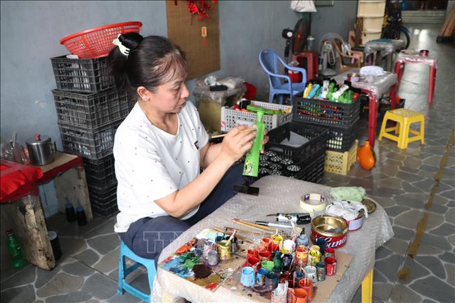 Một trong những người thợ nữ được đào tạo để tiếp tục gìn giữ nghề qua từng nét vẽ. Ảnh: Huyền Trang - TTXVN 