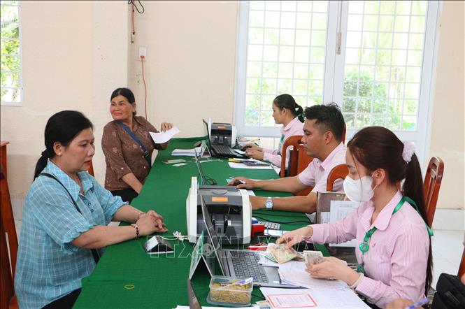 Hội viên phụ nữ đến giao dịch tại điểm giao dịch xã  Hòa Bình, thuộc Phòng Giao dịch Ngân hàng Chính sách xã hội Trà Ôn, tỉnh Vĩnh Long. Ảnh: Lê Thúy Hằng - TTXVN. 