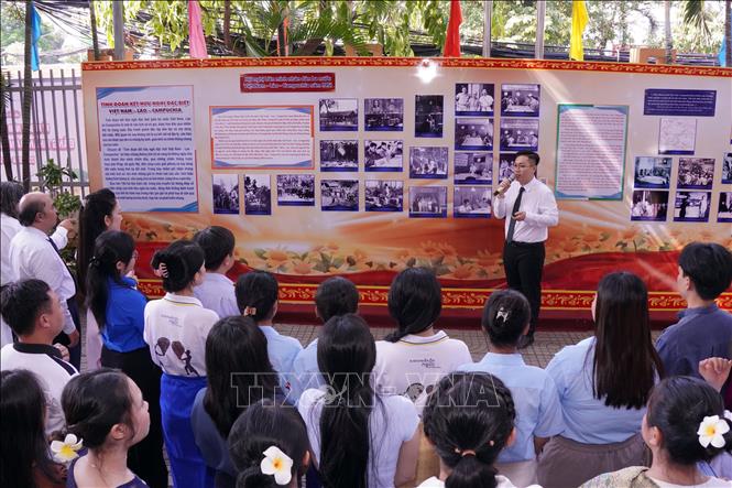 Quý vị đại biểu cùng các bạn sinh viên cùng tham quan trưng bày chuyên đề “Tình đoàn kết hữu nghị đặc biệt Việt Nam - Lào - Campuchia”. Ảnh: Trung Tuyến – TTXVN