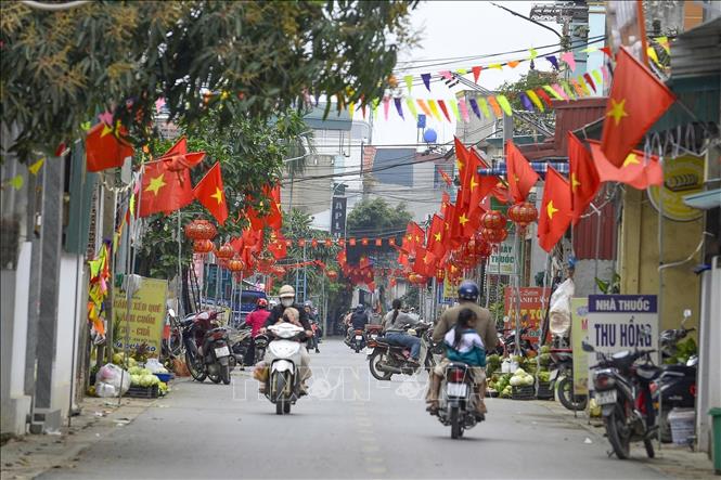 Cờ, hoa, băng rôn, khẩu hiệu rực rỡ khắp làng trên xóm dưới, tạo nên khí thế sôi nổi trước ngày hội lớn của toàn dân. Ảnh: Hoa Mai - TTXVN