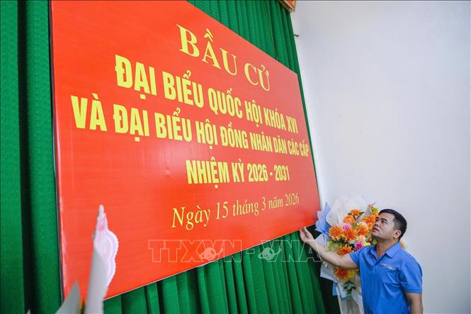 Thực hiện công tác trang trí tại khu vực bỏ phiếu Nhà văn hóa thôn Minh Hùng, xã Vạn Lộc. Ảnh: Hoa Mai - TTXVN