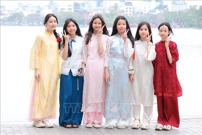 Học sinh trường THCS Huy Văn với những tà áo dài đầy màu sắc bên hồ Hoàn Kiếm. Ảnh: Phạm Tuấn Anh - TTXVN