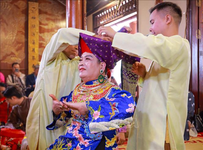 Trong nghi thức hầu đồng, các đồng thầy và thanh đồng được đệ tử chuẩn bị và thay trang phục trực tiếp cho các giá đồng tiếp theo. Ảnh: Khánh Hoà - TTXVN