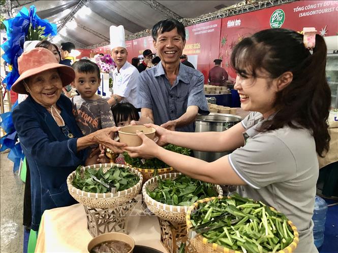 Người dân phấn khởi nhận những suất phở yêu thương. Ảnh: Mỹ Phương - TTXVN