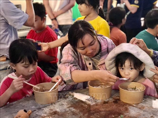 Nhiều gia đình cùng nhau thưởng thức các suất phở yêu thương. Ảnh: Mỹ Phương - TTXVN.