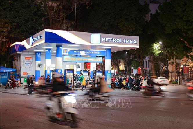 Dòng người và phương tiện xếp hàng chờ đổ xăng tại cây xăng Petrolimex ngã 5 Trần Hưng Đạo - Hàn Thuyên (Hà Nội) vào tối 7/3/2026. Ảnh: Phạm Tuấn Anh - TTXVN