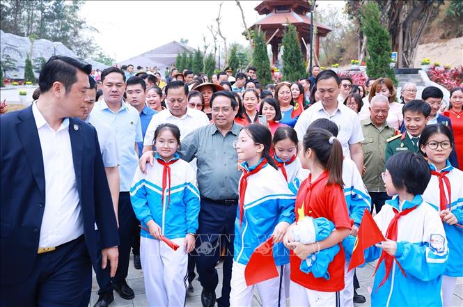 Thủ tướng Phạm Minh Chính với học sinh tỉnh Điện Biên dự Lễ khánh thành công trình bảo tồn, tôn tạo di tích Khu trung tâm đề kháng Him Lam (giai đoạn II). Ảnh: Dương Giang-TTXVN 
