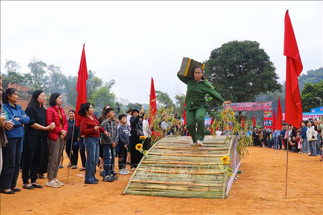 Các vận động viên tham gia phần thi tải đạn vượt qua chướng ngại vật. Ảnh: Phan Quân - TTXVN