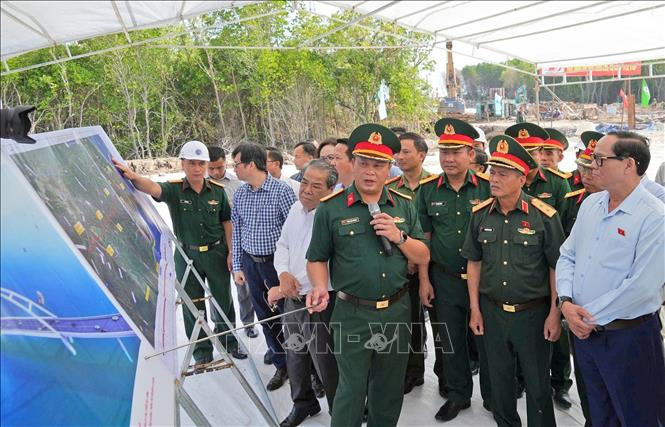 Phó Chủ tịch Quốc hội Trần Quang Phương nghe đại diện Binh đoàn 12 báo cáo tiến độ thi công các công trình trọng điểm quốc gia tại địa bàn xã Đất Mũi. Ảnh: Huỳnh Anh - TTXVN