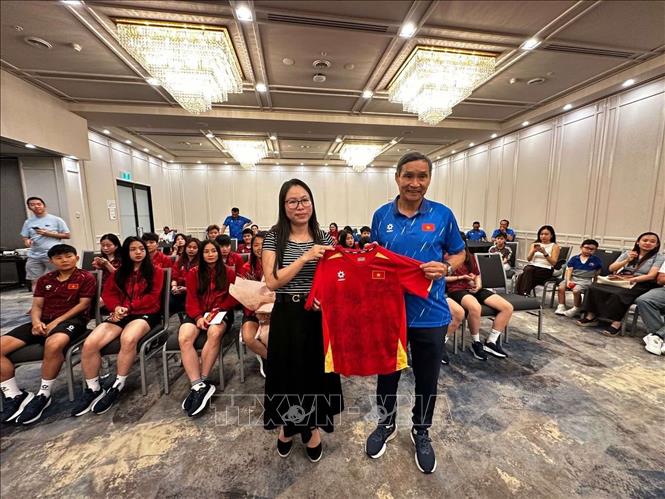 Huấn luyện viên Mai Đức Chung (phải) tặng áo thi đấu có chữ ký của các cầu thủ đội tuyển cho Tổng Lãnh sự Nguyễn Thanh Hà. Ảnh: Thanh Tú - TTXVN tại Australia