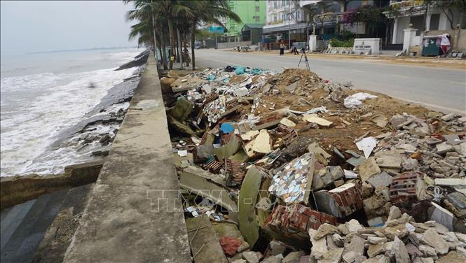 Tuyến đường giao thông dọc tuyến kè bị sập gãy, phía giáp tường chắn sóng đất cát nền đã bị sụt, sạt hoàn toàn. Ảnh: Hoa Mai - TTXVN
