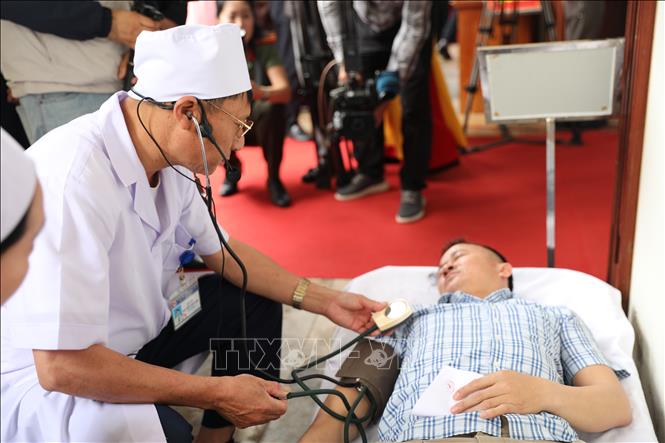 Xử lý tình huống cử tri bị ngất trong quá trình bỏ phiếu tại điểm vận hành bầu cử mẫu ở số 58, Nhà văn hóa tổ dân phố Bình Minh, phường Hạc Thành. Ảnh: Khiếu Thị Tư - TTXVN 