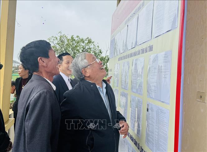 Cử tri xã Lộc Hà theo dõi danh sách đại biểu được niêm yết tại khu vực bỏ phiếu. Ảnh: Hoàng Ngà - TTXVN