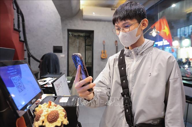 Chỉ với một chiếc điện thoại thông minh, người dân có thể dễ dàng hoàn tất giao dịch thanh toán trong vài giây. Ảnh: Lê Đông - TTXVN