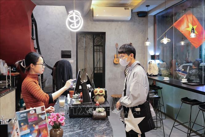 Người dân thanh toán điện tử khi mua hàng, góp phần thúc đẩy xu hướng tiêu dùng không tiền mặt. Ảnh: Lê Đông - TTXVN