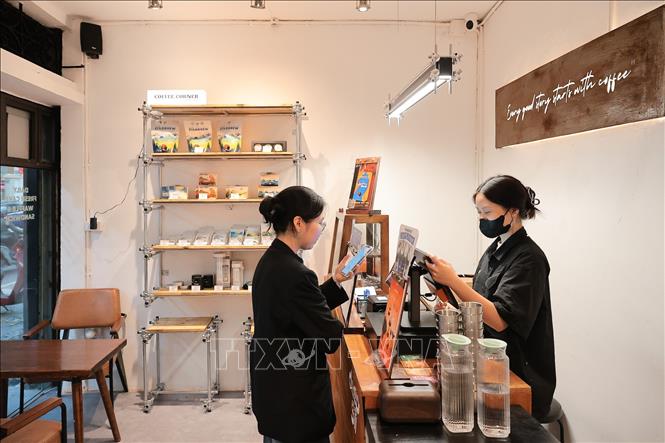 Người dân sử dụng mã QR để thanh toán tại cửa hàng đồ uống trên đường Phan Huy Chú (Hà Nội). Ảnh: Lê Đông - TTXVN