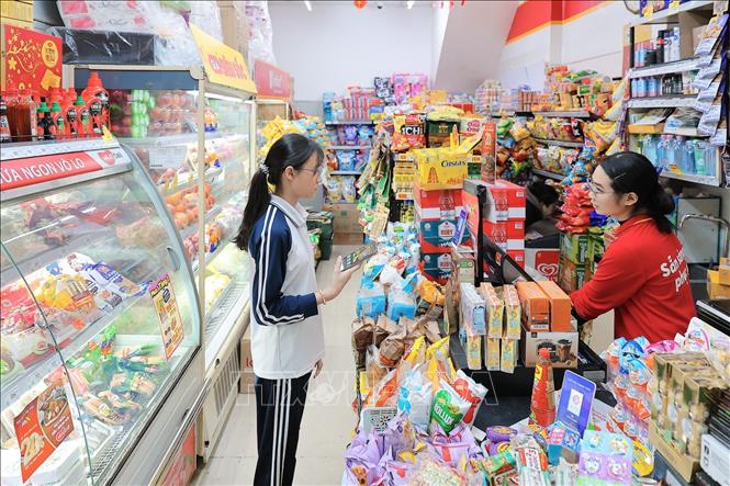 Người dân thanh toán điện tử khi mua hàng, góp phần thúc đẩy xu hướng tiêu dùng không tiền mặt. Ảnh: Lê Đông - TTXVN