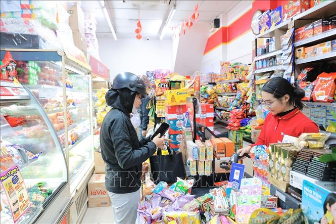 Người dân thanh toán điện tử khi mua hàng, góp phần thúc đẩy xu hướng tiêu dùng không tiền mặt. Ảnh: Lê Đông - TTXVN
