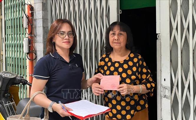 Thẻ cử tri được trao tận tay từng người trong danh sách cử tri được niêm yết công khai tại các phường, xã. Ảnh: Hữu Duyên - TTXVN 