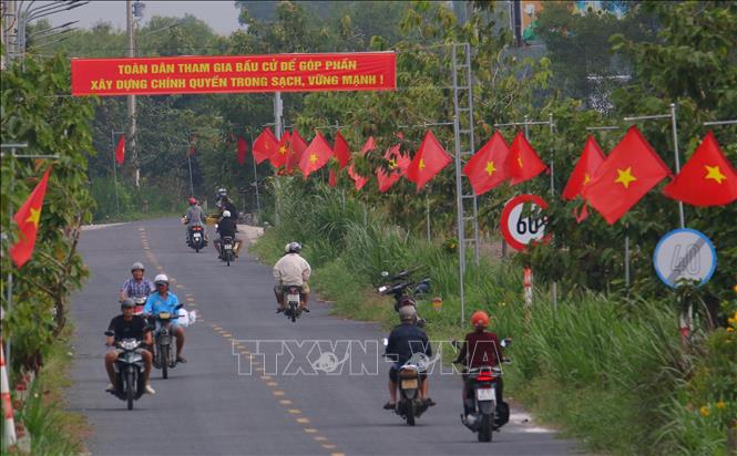 Treo băng rôn, khẩu hiệu tuyên truyền cuộc bầu cử trên đường 931, xã Vĩnh Viễn, thành phố Cần Thơ. Ảnh: Duy Khương – TTXVN