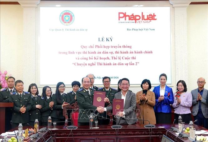 Ông Nguyễn Thắng Lợi, Cục trưởng Cục Quản lý Thi hành án dân sự (Bộ Tư pháp) và ông Vũ Hoài Nam, Tổng Biên tập Báo Pháp luật Việt Nam ký Quy chế phối hợp. Ảnh: Chu Thanh Vân - TTXVN