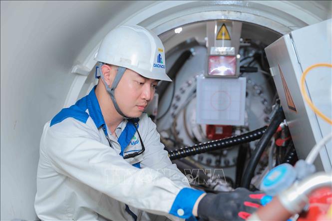 Kỹ sư kiểm tra định kỳ đầu máy khoan kích ngầm trước khi vận hành hệ thống máy khoan AVN của Herrenknecht CHLB Đức theo công nghệ tiên tiến, nhằm bảo đảm thiết bị hoạt động ổn định, an toàn và đáp ứng yêu cầu kỹ thuật của dự án. Ảnh: Phan Phương – TTXVN