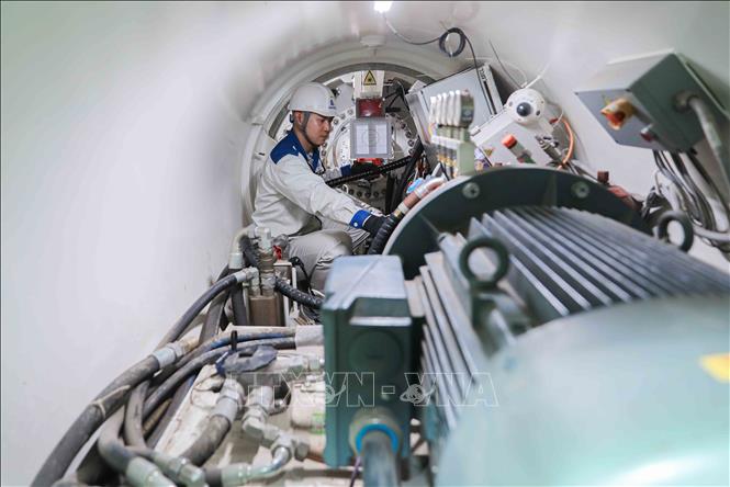 Kỹ sư kiểm tra định kỳ đầu máy khoan kích ngầm trước khi vận hành hệ thống máy khoan AVN của Herrenknecht CHLB Đức theo công nghệ tiên tiến, nhằm bảo đảm thiết bị hoạt động ổn định, an toàn và đáp ứng yêu cầu kỹ thuật của dự án. Ảnh: Phan Phương – TTXVN