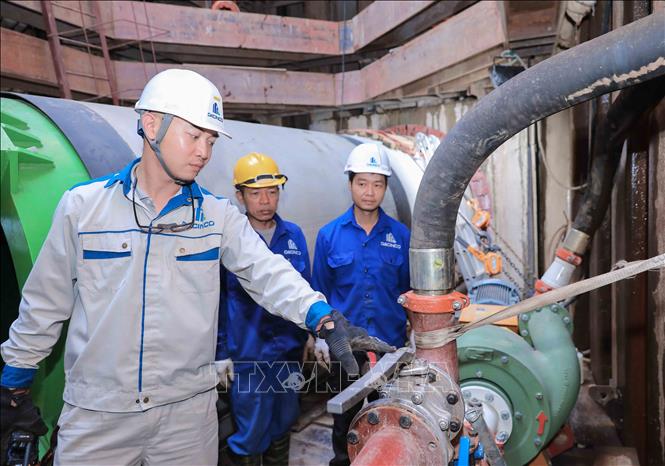 Kỹ sư hướng dẫn công nhân vận hành hệ thống bơm bùn dưới giếng khoan ở độ sâu 12–15 m tại dự án xử lý nước thải TP Hà Nội. Ảnh: Phan Phương – TTXVN
