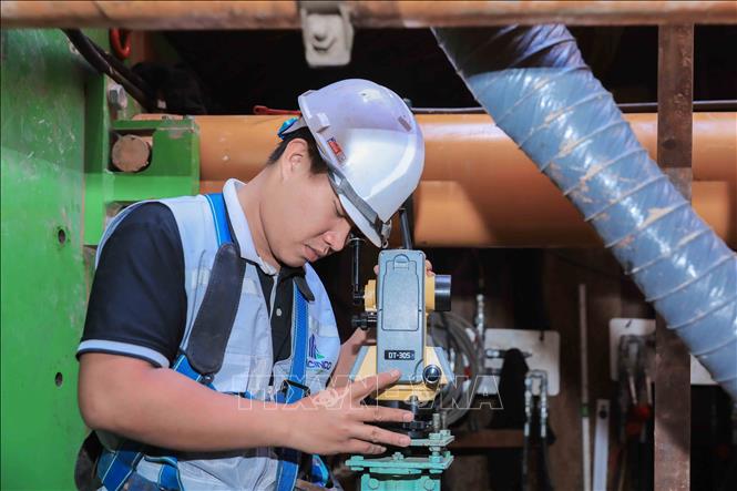 Kỹ sư điều khiển máy laser định vị tim tuyến, bảo đảm hướng khoan chính xác theo thiết kế kỹ thuật của dự án. Ảnh: Phan Phương – TTXVN