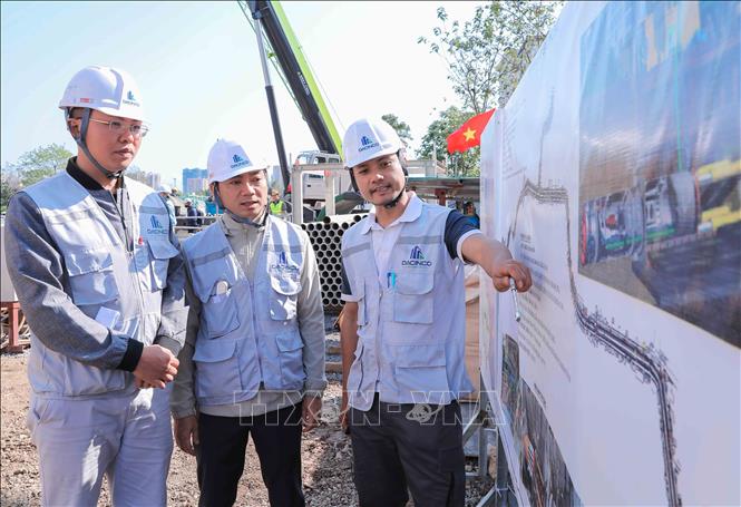 Ông Trần Duy Tuấn, phụ trách công trường gói thầu 49 cùng các kỹ sư thường xuyên theo dõi, giám sát tiến độ thi công ngày đêm, quyết tâm đẩy nhanh tiến độ, bảo đảm dự án hoàn thành sớm theo chỉ đạo của UBND TP Hà Nội. Ảnh: Phan Phương – TTXVN