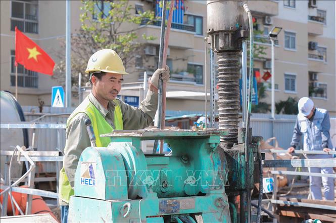 Công nhân bơm hỗn hợp gia cố nền đất tại giếng khoan gói thầu 49, xây dựng tuyến cống bao sông Lừ thuộc dự án xử lý nước thải TP Hà Nội. Ảnh: Phan Phương – TTXVN