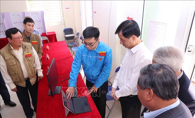 Đoàn viên thanh niên phường Hồng Hà báo cáo với Bí thư Thành ủy Hà Nội Nguyễn Duy Ngọc về quy trình bỏ phiếu tại Khu vực bỏ phiếu số 27. Ảnh: Văn Điệp - TTXVN