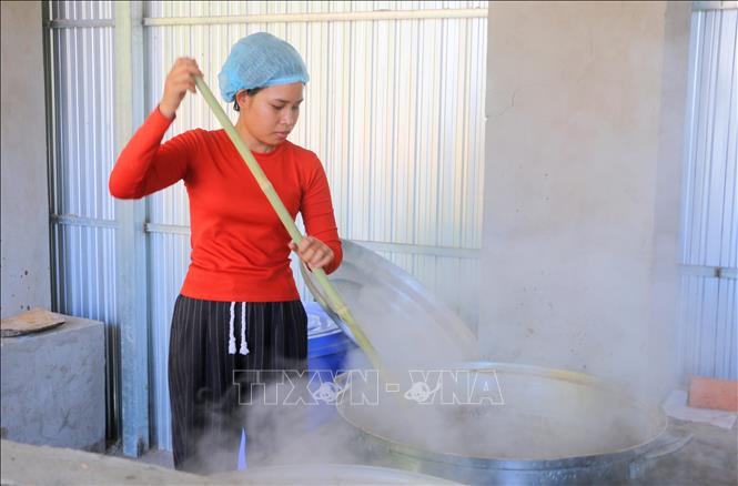 Sau công đoạn lọc sạch tạp chất, nước thốt nốt tươi được đưa vào chảo lớn, đun liên tục từ 3 đến 4 giờ đồng hồ. Quá trình nấu đường thốt nốt, người nấu phải khuấy liên tục và vớt lớp bọt lẫn những tạp chất cho đến khi hơi nước bên trong đường bốc hơi và đường cô đặc lại thì mới ngừng. Ảnh: Công Mạo-TTXVN