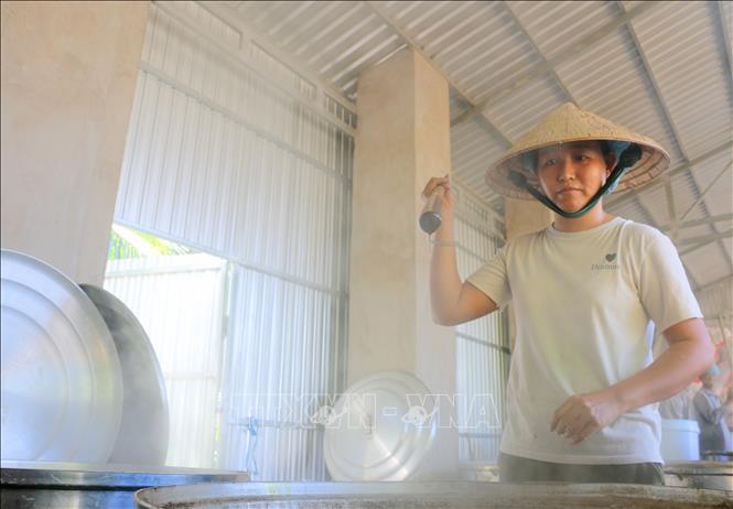 Bằng kinh nghiệm, người thợ chỉ cần nhìn màu nước thốt nốt cũng có thể biết được hàm lượng của đường bên trong nồi trước khi nấu. Ảnh: Công Mạo-TTXVN