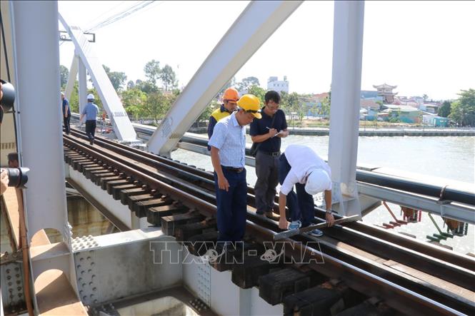 Cán bộ đường sắt tiến hành đo, kiểm tra đường ray để thử nghiệm chuyến tàu đầu tiên qua cầu Ghềnh, sau sự cố sà lan đâm va gây gián đoạn tuyến đường sắt Bắc - Nam. Ảnh: Sỹ Tuyên - TTXVN