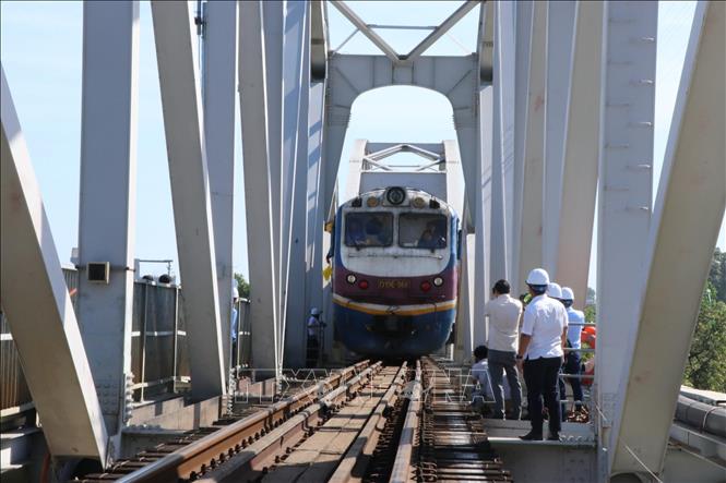 Lúc 9 giờ ngày 11/3/2026, đoàn tàu số hiệu đầu máy D19E-966, với tải trọng khoảng 1.000 tấn lưu thông qua cầu Ghềnh, sau 6 ngày bị gián đoạn do sự cố sà lan đâm va gây hư hỏng. Ảnh: Sỹ Tuyên - TTXVN