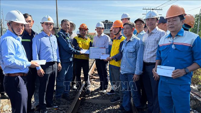 Lãnh đạo ngành đường sắt tặng quà cho công nhân, kỹ sư đã nỗ lực khắc phục, sớm đưa cầu Ghềnh khai thác trở lại sau sự cố sà lan đâm va. Ảnh: Sỹ Tuyên - TTXVN