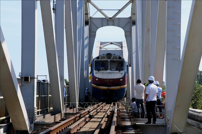 Lúc 9 giờ ngày 11/3/2026, đoàn tàu số hiệu đầu máy D19E-966, với tải trọng khoảng 1.000 tấn lưu thông qua cầu Ghềnh, sau 6 ngày bị gián đoạn do sự cố sà lan đâm va gây hư hỏng. Ảnh: Sỹ Tuyên - TTXVN