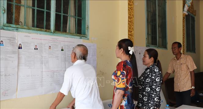 Đồng bào Khmer ấp Ngã Cạy, xã Xà Phiên tìm hiểu thông tin về ứng cử viên đại biểu Quốc hội và HĐND được niêm yết tại chùa Bôrâysarâychum. Ảnh: Hồng Thái - TTXVN