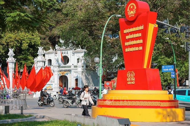 Những ngày này, nhiều tuyến phố tại Hà Nội được trang hoàng rực rỡ với cờ Đảng, cờ Tổ quốc và các cụm pano, băng rôn chào mừng Ngày hội toàn dân đi bầu cử 15/3. Ảnh: Hoàng Hiếu - TTXVN