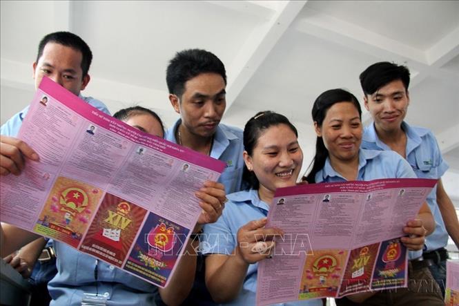 Công nhân Công ty Giày Thái Bình (phường Bình An, thị xã Dĩ An, Bình Dương) tìm hiểu tiểu sử ứng cử viên tham gia ứng cử nhiệm kỳ Quốc hội XIV ngay tại nhà máy (20/5/2016). Ảnh: Dương Chí Tưởng-TTXVN
