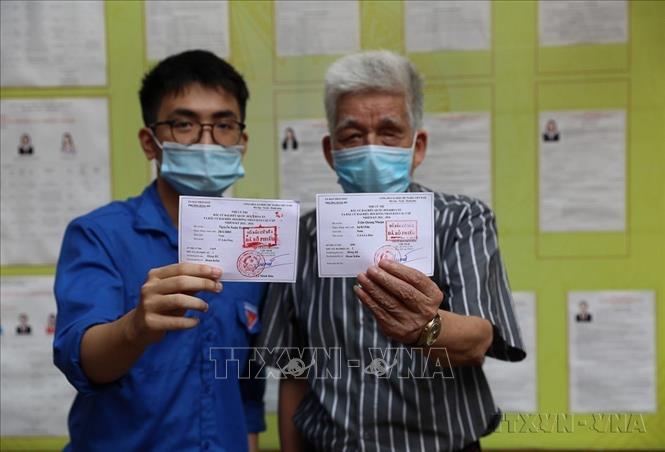 Cụ Trần Quang Nhuận (SN 1946) là người sinh vào năm bầu cử Quốc hội khóa I và  anh Nguyễn Xuân Trường (SN 2003) là người lần đầu tiên đi bầu cử, đã hoàn thành bầu Đại biểu Quốc hội khóa XV và đại biểu HĐND các cấp nhiệm kỳ 2021 – 2026 (Hà Nội, 23/5/2021). Ảnh: Phạm Hậu – TTXVN