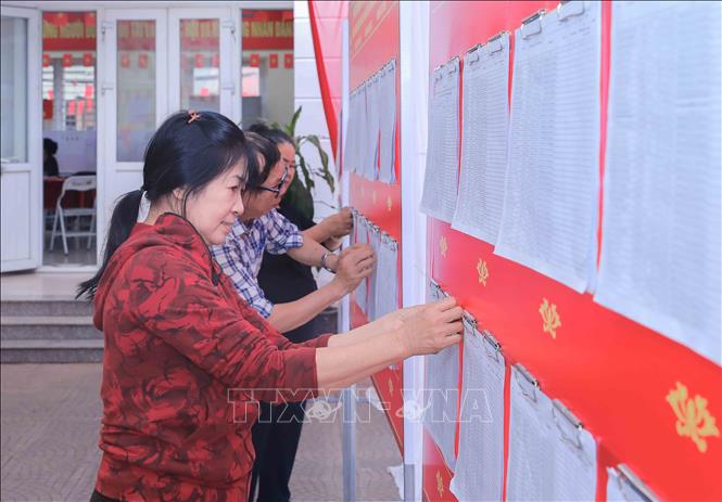 Cán bộ Tổ bầu cử khu vực bỏ phiếu số 22, đơn vị bầu cử số 5, phường Việt Hưng, TP Hà Nội, niêm yết danh sách người ứng cử trước điểm bầu cử. Ảnh: Phan Phương – TTXVN