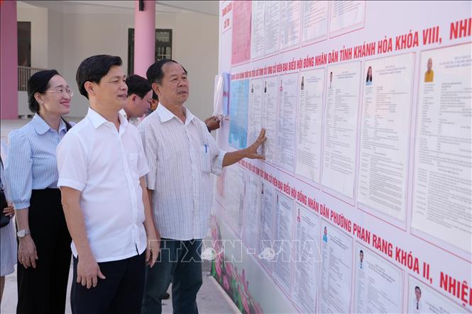 Ông Lê Hoài Nam (áo sơ mi trắng), Chủ tịch UBND phường Phan Rang kiểm tra khu vực niêm yết danh sách những người ứng cử đại biểu Quốc hội khóa XVI và đại biểu Hội đồng nhân dân các cấp nhiệm kỳ 2026–2031 tại khu vực bỏ phiếu số 11 trên địa bàn phường. Ảnh: Nguyễn Thành – TTXVN.